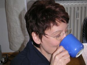 Eine Frau nimmt einen kräftigen Schluck aus einer Tasse.