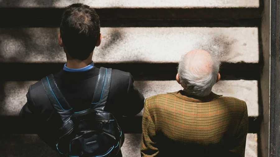 Jung und Alt auf einer Treppe zusammen nach oben